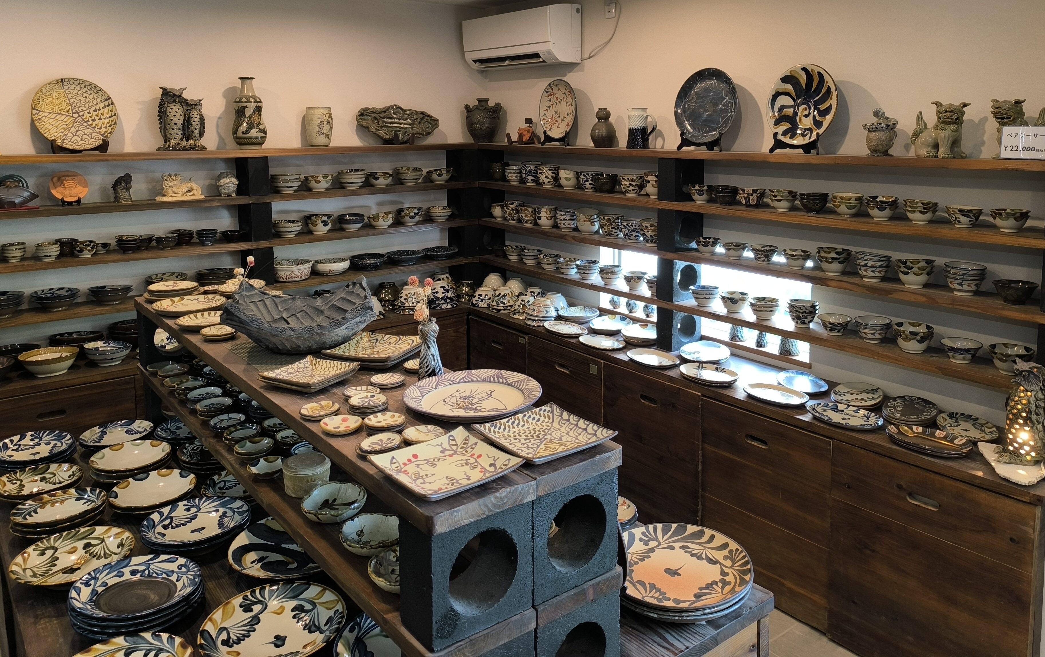 多様な柄のやちむんが並ぶ売り場風景