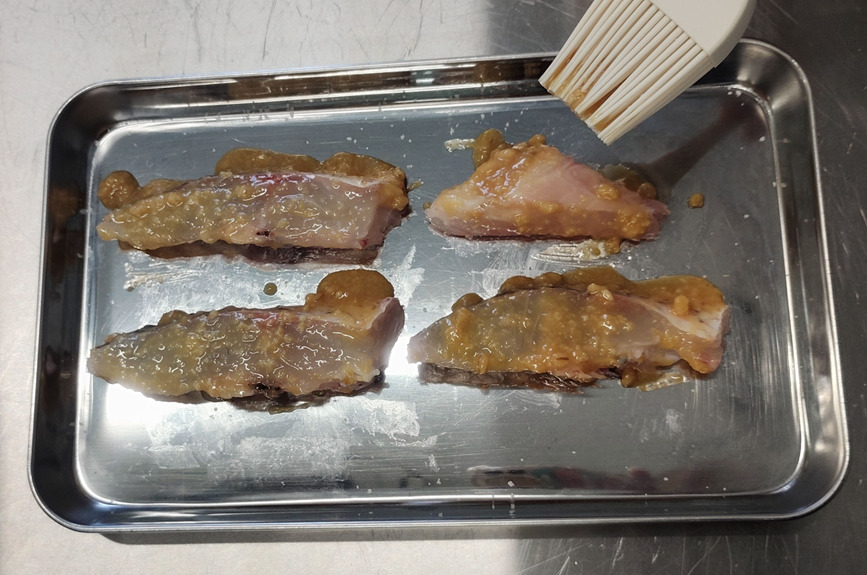 味噌だれを白身魚に塗っている工程