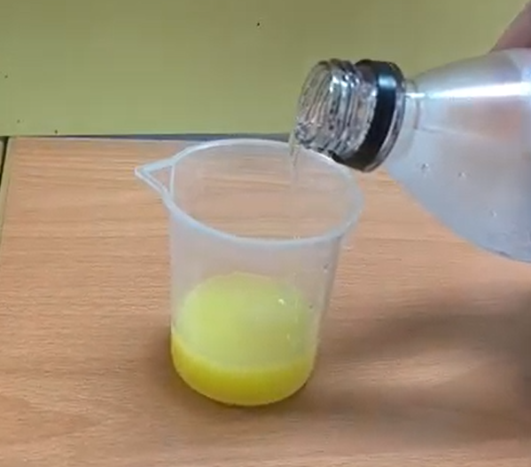 青切りシークヮーサーに炭酸水を少量加えて軽く混ぜている様子