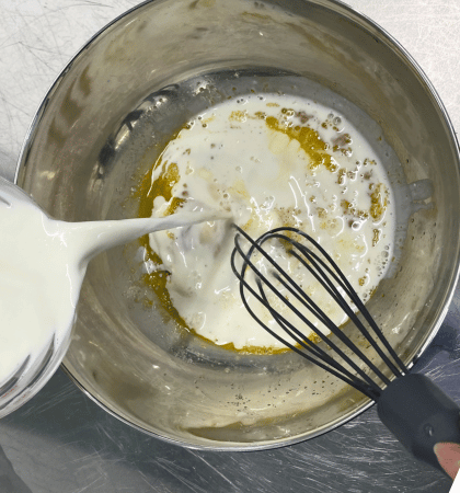 牛乳と生クリームを卵液に混ぜ合わせる様子